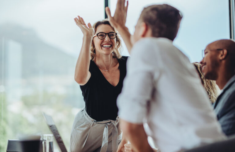 Businesswoman giving a high five to a colleague in meeting